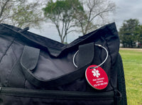 Black bag with a red emergency tag on a grassy field