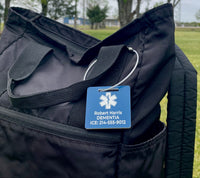 Black bag with blue tag labeled 'Robert Harris DEMENTIA' on grass.