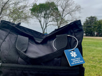 Black bag with a blue tag on a grassy background