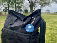 Black bag with a blue tag on a grassy field