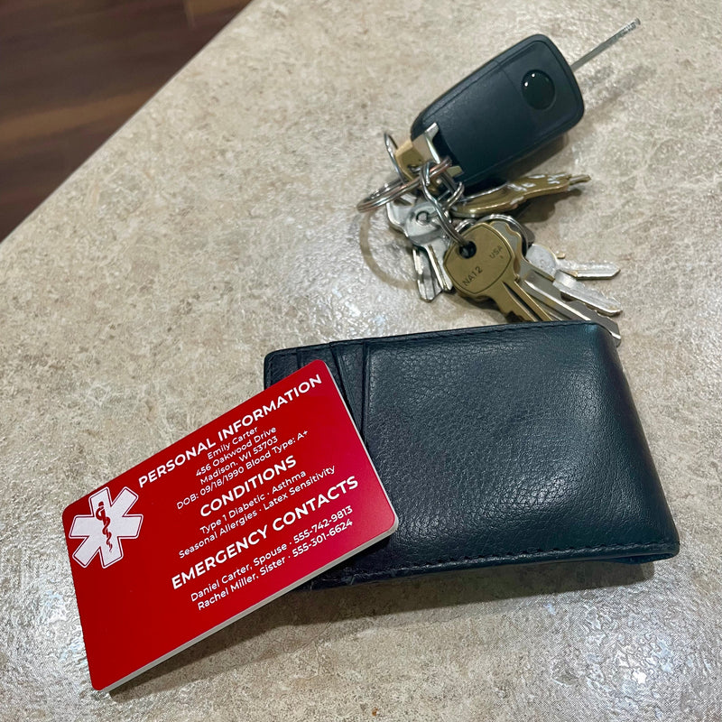 Black wallet, red emergency contact card, and keys on a textured surface